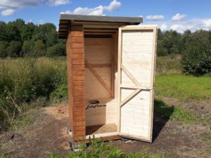 Деревянный односкатный туалет в поле